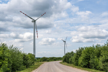 rotating blades of a windmill propeller on blue sky background. Wind power generation. Pure green energy.