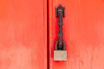 The padlock hangs on the red wooden door