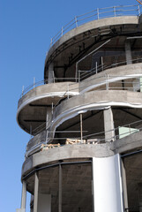 Building Under Construction with Curved Facade against Blue Sky 