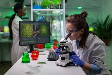 Portrait of biologist scientist in white coat working in expertise laboratory looking into...