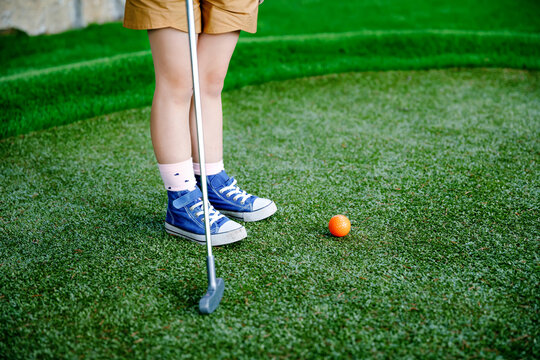 Cute Preschool Girl Playing Mini Golf With Family. Happy Toddler Child Having Fun With Outdoor Activity. Summer Sport For Children And Adults, Outdoors. Family Vacations Or Resort.