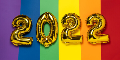 pride 2022 banner. golden balls numbers 2021 on a rainbow flag background