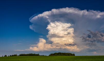 Isolated cumulonimbus storm clouds in the blue sky