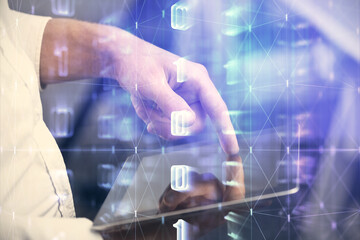 Double exposure of man's hand holding and using a digital device and data theme hologram drawing. Technology concept.