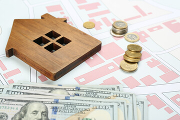 Money and wooden house model on cadastral map