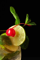 Frozen glass with a Mojito garnished with a preserved cherry.