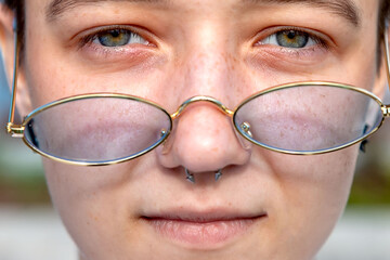 teen girl with glasses with piercings, close-up