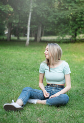 Naklejka na ściany i meble Photo of cute adorable woman sitting on fresh green grass