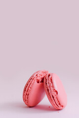 Pink macaroons on a uniform background, crumbled piece, front view, copy space.