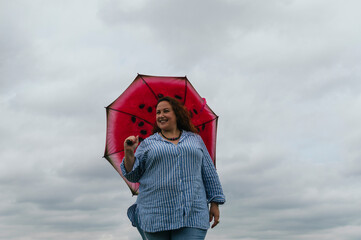 Young girl with a red umbrella in a park