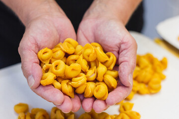Hands holding Tortellini bolognesi, Italian pasta