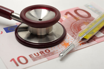 Costs and revenues in the health sector with euro banknote and stethoscope