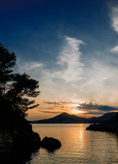 Beautiful boat on a background of mountains, sunset over the sea