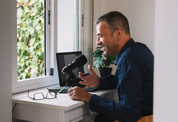 Middle-aged man conducting a podcast at home.
Conceptual of lifestyle