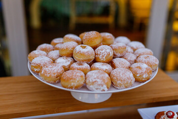 Bignè fritti, ripieni di crema e spolverati con zucchero a velo pronti per un buffet di dolci di...