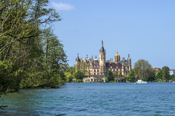 Schwerin castle against a blue sky seen from the lake, famous landmark and tourist attraction of the state capital city of Mecklenburg-Vorpommern, Germany, copy space