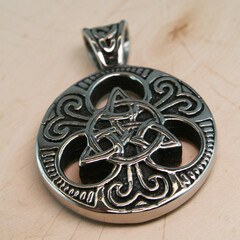 nordic silver pendant on a wooden plate