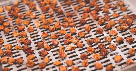 Fototapeta premium The process of cooking dry yellow cherries in an electric automatic dryer at home.