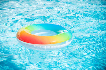 Inflatable ring in blue swimming pool. Colorful inflatable toy in swimming pool water, summer vacation background.