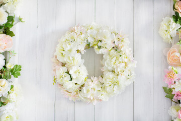 Flower arrangement . a wreath of delicate flowers on a white wooden background. Invitation,...