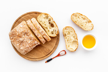 Sliced bread ciabatta with oil on cutting board, top view - obrazy, fototapety, plakaty