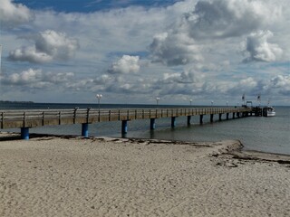 Naklejka premium Seebrücke mit Strand, Ostsee, Himmel und Wolken in Haffkrug