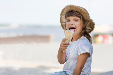 happy child girl  in sun hat eat ice cream in a summer park. Summer holiday
