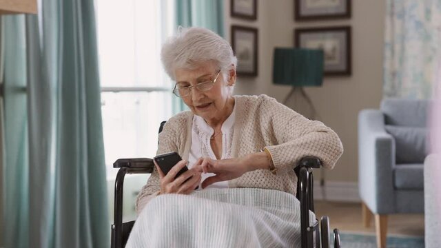 Senior woman using smartphone on wheelchair
