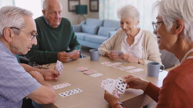 Senior friends playing cards together at nursing home