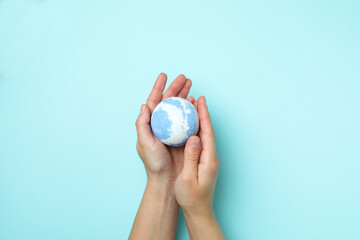 Female hands hold bath ball on blue background