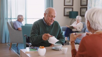 Senior man drinking hot tea with his wife at retirement community