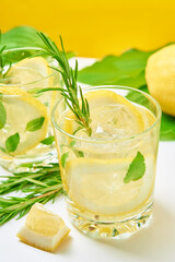 Summer alcoholic cocktail. Refreshment lemon soda drink. Gin and tonic with lemon and rosemary on table