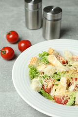 Concept of tasty eating with Caesar salad on gray textured background
