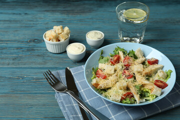 Concept of tasty eating with Caesar salad on wooden table
