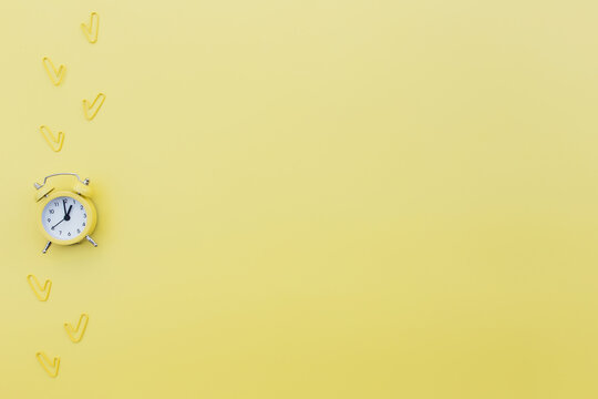 Back to school or office work conceptual flat lay with alarm clock and clips