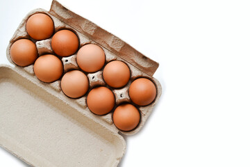 Cardboard package with a dozen eggs on a white background top view, copy space.