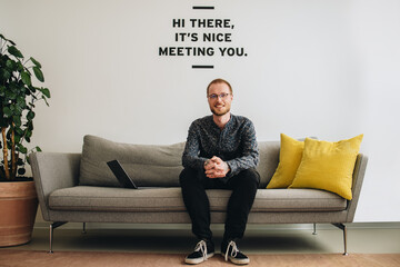 Confident entrepreneur sitting in lobby