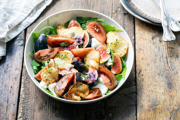 Fresh figs and mozzarrella cheese salad with grilled peach slices and tomatoes