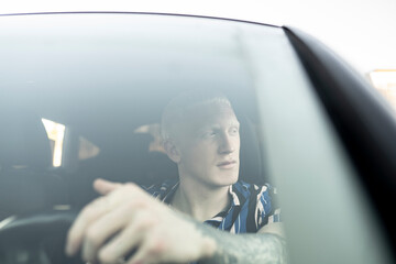 albino blond young man driving car