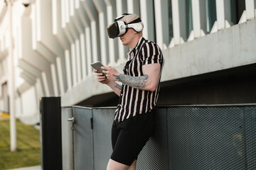 albino blond man using virtual reality glasses, in the city