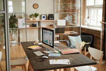 Image of empty board room with table with monitor computer on it in the middle of the room