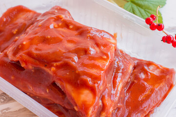 Fresh pork ribs, meat marinated and prepared for roast with red currants sauce