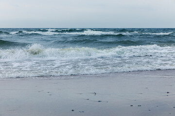 Baltic Sea coast in Poland, waves, sea foam, sky and beach