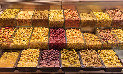 Different type of olives on the counter of a shop