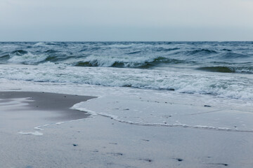 Baltic Sea coast in Poland, waves, sea foam, sky and beach