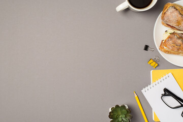 Top view photo of cup of coffee plate with two sandwiches flowerpot glasses binder clips yellow pencil and notepads on isolated grey background with empty space