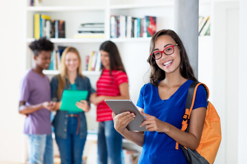 Beautiful nerdy female student with tablet computer with group of multi ethnic college students