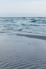 Baltic Sea coast in Poland, waves, sea foam, sky and beach