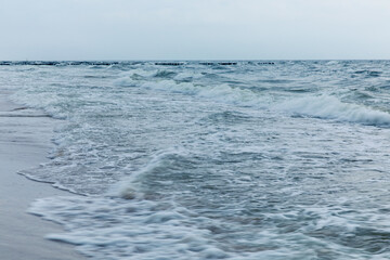 Baltic Sea coast in Poland, waves, sea foam, sky and beach