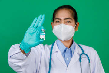 Focusing on asian female doctor wearing lab coat hand holding syringe and Covid 19 vaccine vial bottle. Concept for Covid 19 vaccination